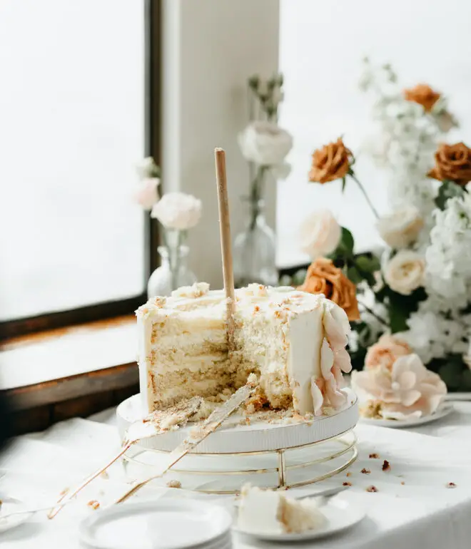 Partially served wedding cake displayed during a destination wedding reception aboard an Amsterdam canal boat