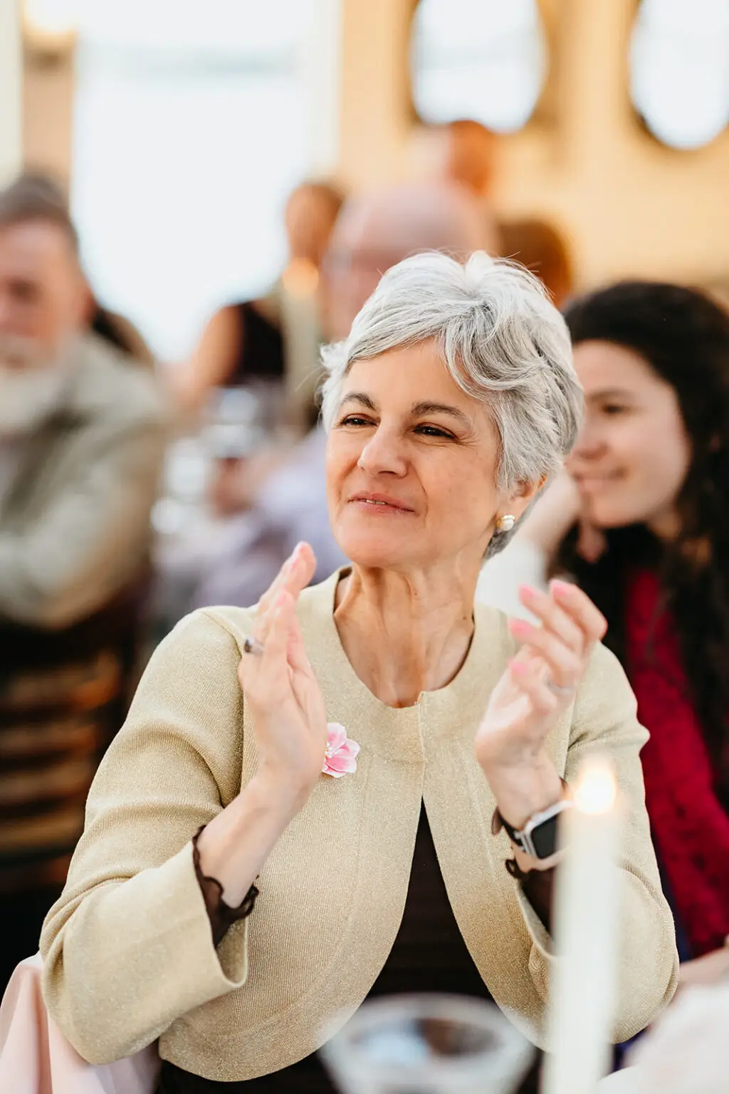 Wedding guest applauding during speeches at a destination wedding reception aboard an Amsterdam canal boat
