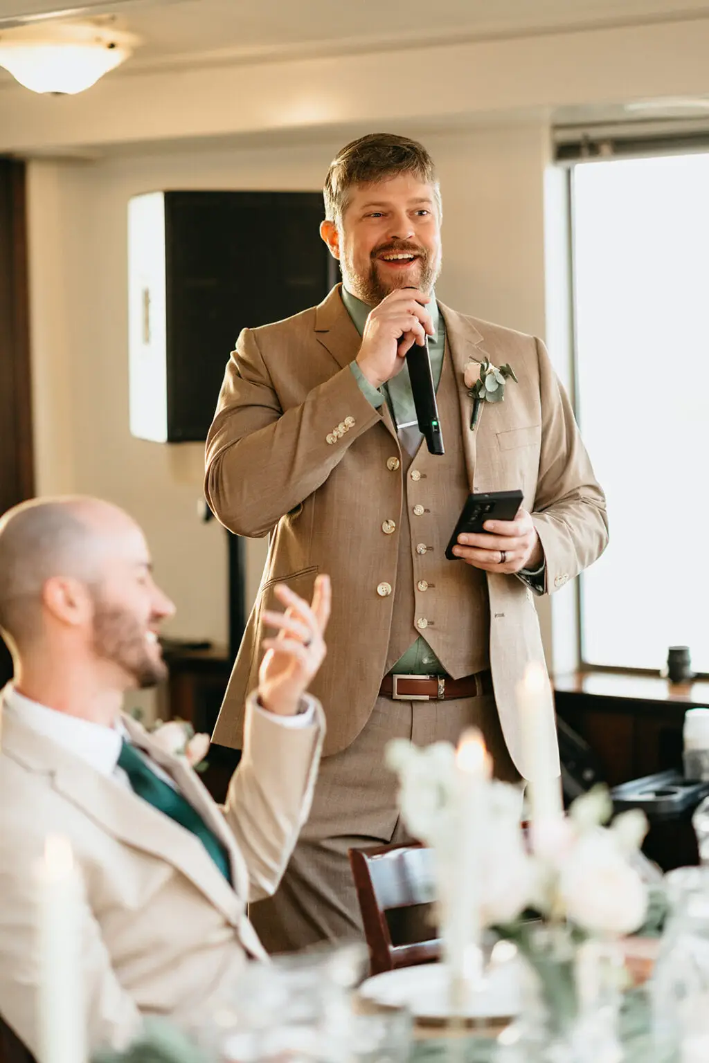 Wedding guest giving a speech during a destination wedding reception aboard an Amsterdam canal boat