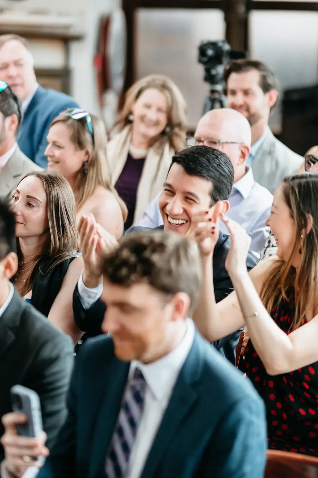 Wedding guests smiling and applauding during the ceremony aboard Het Wapen van Amsterdam
